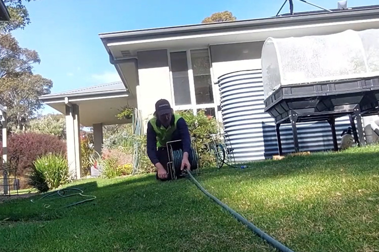 
Wrapping up his daily work, the portstephens downpipe cleaner is neatly storing his hose.